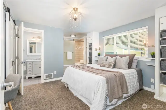 Primary Bedroom on the main floor! Compartmented bath area as well as open jetted tub/shower.  Enjoy the new barn doors and vanity area plus shelving flanking both sides of the bed with individual reading lights.