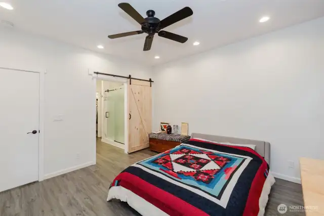 Barn doors lead to the private primary bath.