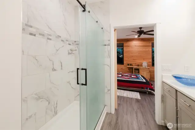 Primary shower with double obscure glass doors and elegant tile surround.