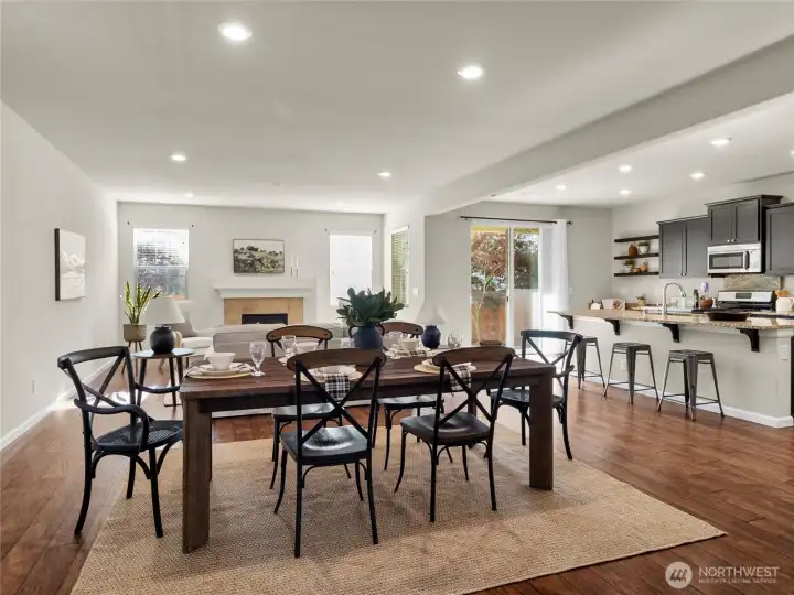 Open-concept design featuring a connected living, dining, and kitchen area with natural light throughout.
