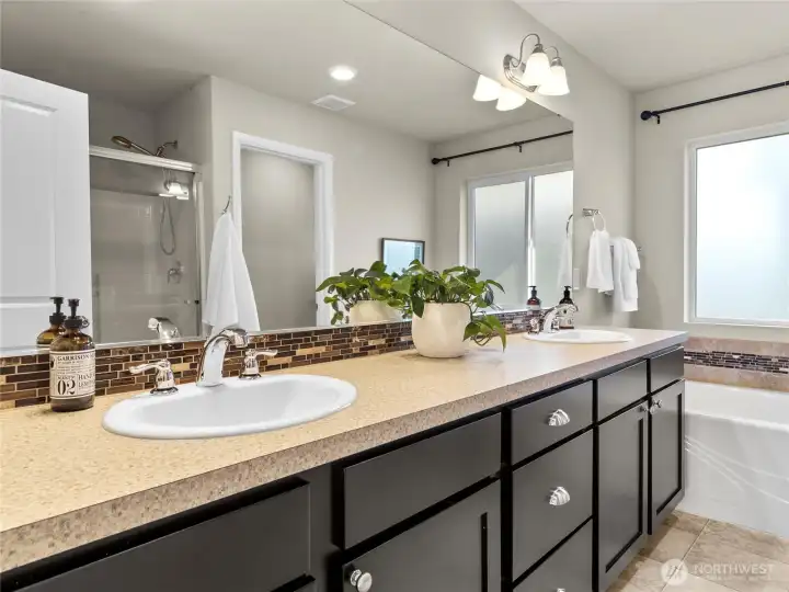 Private ensuite bathroom with dual vanities, soaking tub, and separate shower.