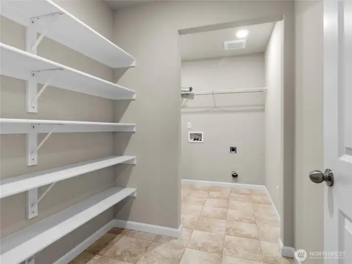 Large laundry area with built-in shelving and plenty of storage options.