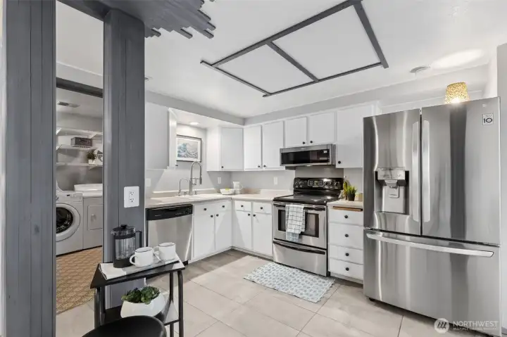 The updated kitchen features a fresh approach with white painted cabinets, and stainless appliances. Imagine your version of portable kitchen island in the passage way, for extra counter space.