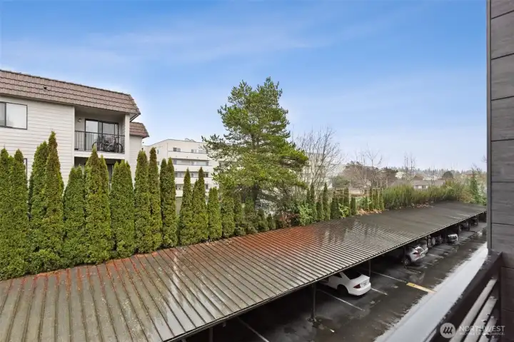 The view from the small balcony shows the view and position of the unit on the quieter, East/SE side of the building. A single, one-car garage with garage door is included with the unit.