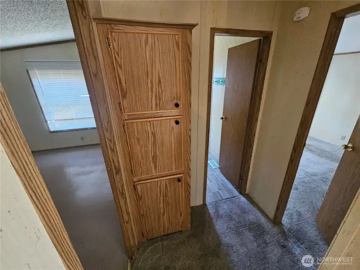 The hallway at the East end of the house has a linen closet next to the bathroom.