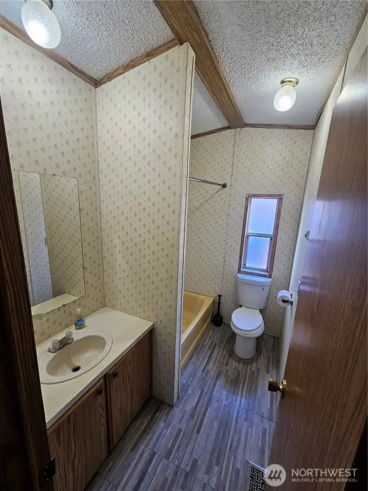 The hall bathroom has a tub with an overhead shower.