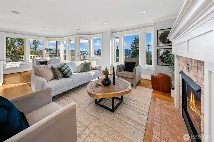 A panorama of view windows span the south side of this house. Views of Elliott Bay, Space Needle, and Downtown Seattle. Cozy gas fireplace anchors the space.