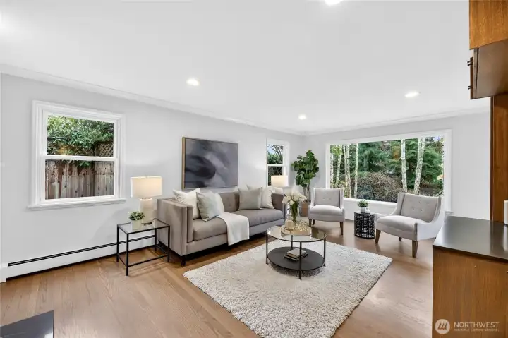 The serene living room is graced with beautiful hardwood floors, & a gas fireplace.