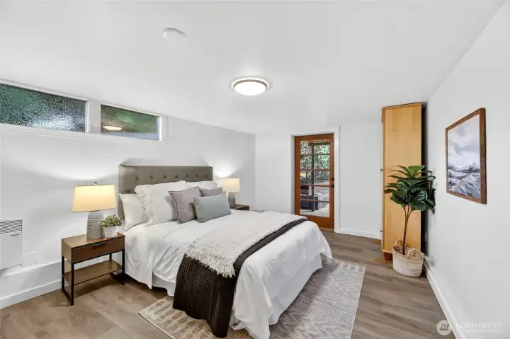 This large bedroom could be a second primary on the main level.  There is room to add another bathroom onto this room. Please see rendering in house.  (Buyer to verify possibility.)  This room also has access to the back deck.  The home features a metal gate on the side of the house that locks for privacy.