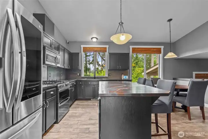Updated kitchen with stainless steel appliances including a gas stove and custom countertops (all to stay with home)