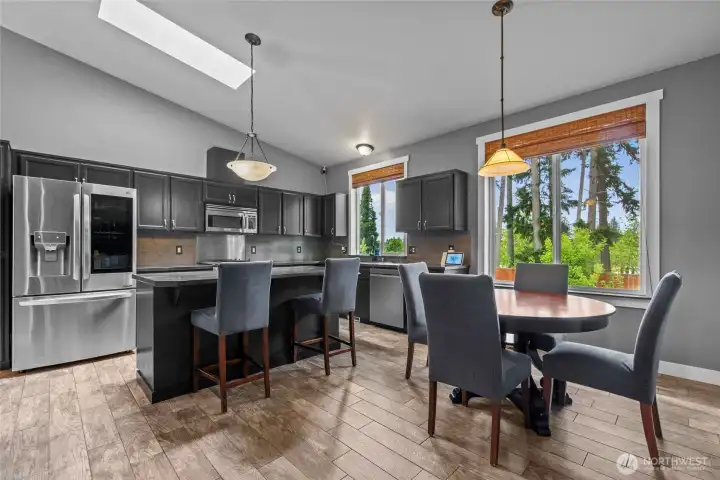 Island with bar seating a room for a kitchen table.