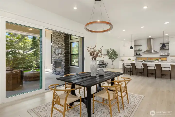 Another view highlighting the effortless connection between the dining room, great room, chef’s kitchen, and covered outdoor living area, designed for exceptional year-round entertaining.