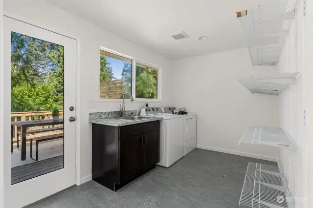 Huge laundry room with tons of storage, utility sink and access to deck.