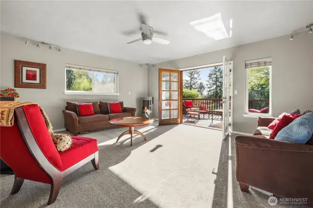 The living room effortlessly opens to the back deck through elegant French doors, creating a seamless indoor-outdoor living experience.