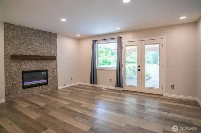 Electric fireplace in family room opens up to patio and outdoor kitchen area.