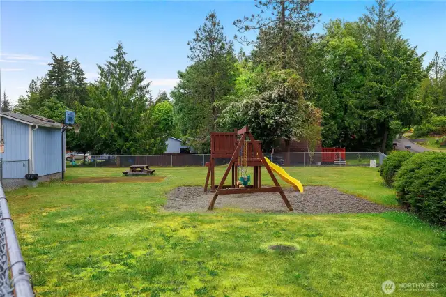 This is one of two fully fenced playgrounds in the community. It even feautres a basketball hoop and a picnic bench making  it a fun spot.