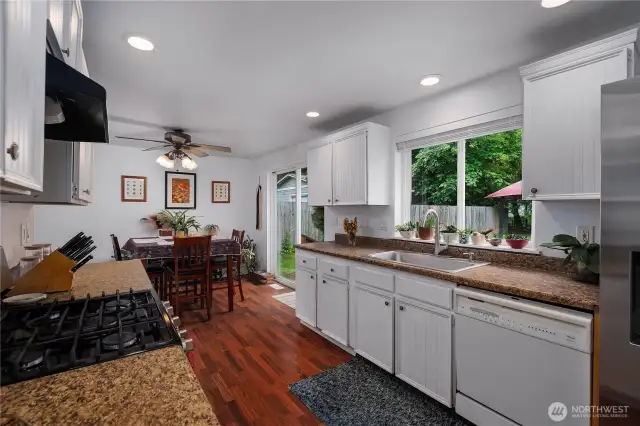 The kitchen opens up to a cozy eat-in dining area, complete with a ceiling fan and sliding door that leads out to the backyard.