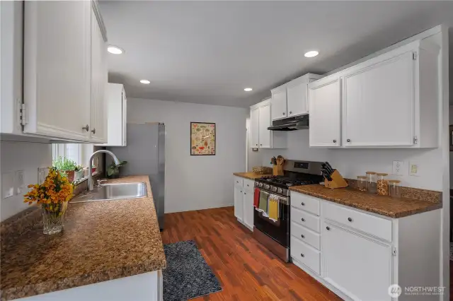 The kitchen has clean white millwork cabinets ands plenty of recessed lighting. The kitchen also features a newer Samsung refrigerator and gas stove, so you're all set with quality appliances. There's even a designated spot for the garbage can-how great is that?