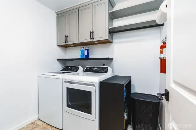 Spacious laundry with custom cabinets/shelving