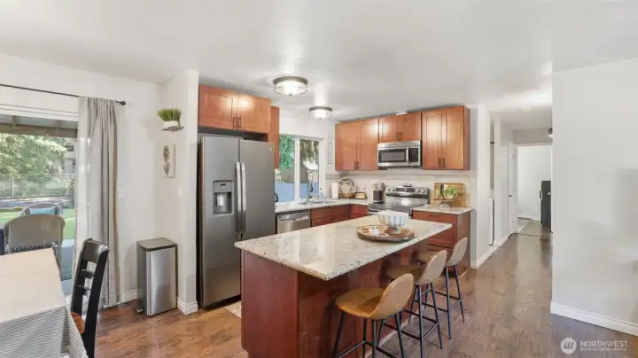 Slab granite countertops with large center island with breakfast bar and all stainless steel appliance package