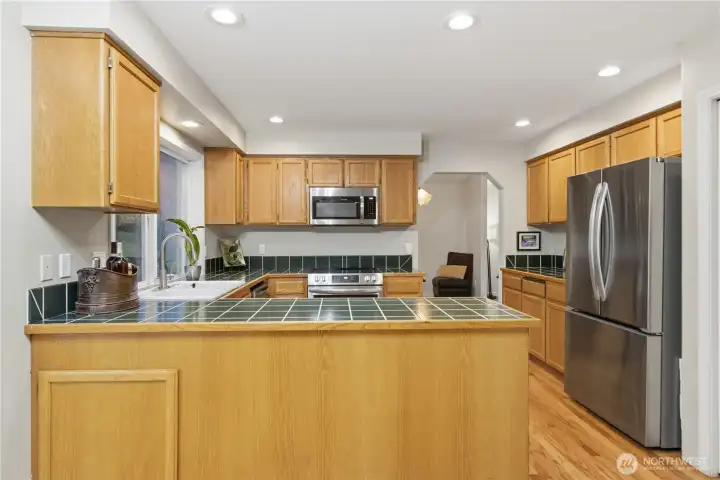Bright functional kitchen with gleaming cabinets, hardwood floors, and plenty of prep space.
