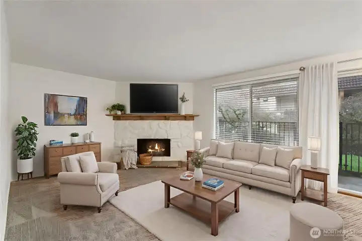 The open living room features a cozy fireplace with charming wood mantle & overlooks the tranquil courtyard. Newer carpeting expands through the space. *Photo virtually staged