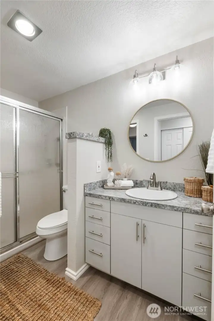 The refreshed bath offers lots of cabinetry with decorate pulls, nice fixtures & low maintenance laminate flooring