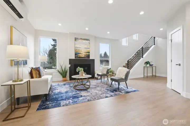 Good size Living room with multiple windows and metal stair case railing to 2nd level
