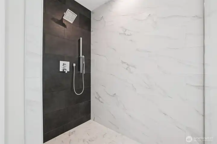 Yes this is primary bathroom with glass enclosure and tiled walls to the ceiling