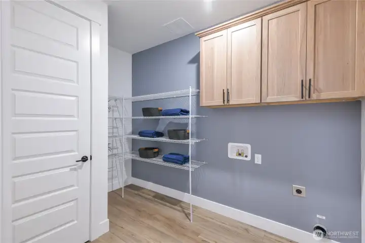 Laundry with extra cabinets and schevling