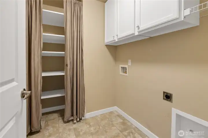 Upstairs laundry with added storage & cabinets.