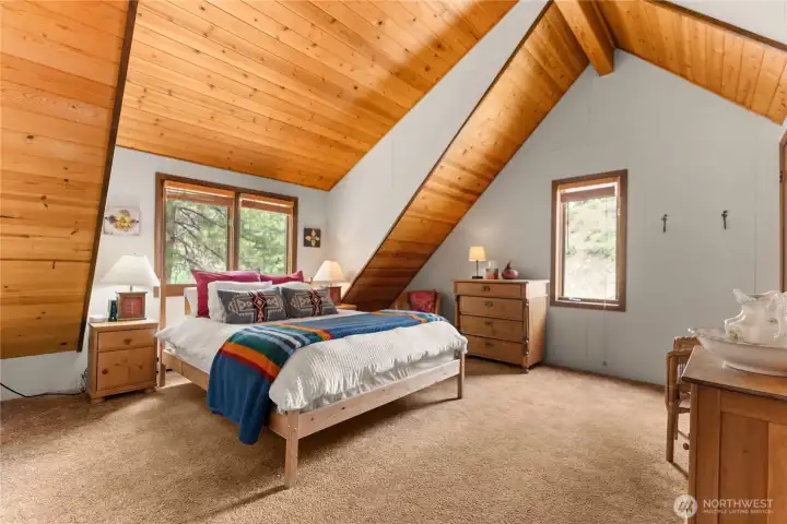 Upstairs primary with vaulted ceilings and natural light.