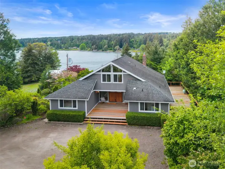 Front view of the home and the view of the bay behind it, lots of parking up front