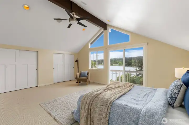 Primary bedroom boast tall vaulted ceilings, large windows and quaint balcony, as well as plenty of closet space