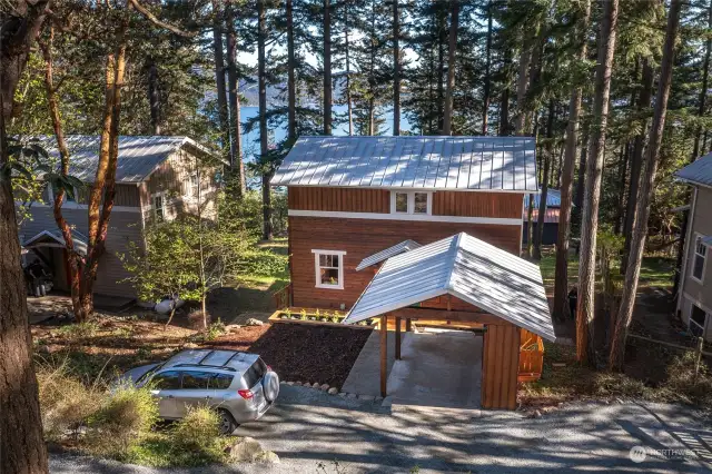 Detached carport, parking space and level front yard on north side of the home.