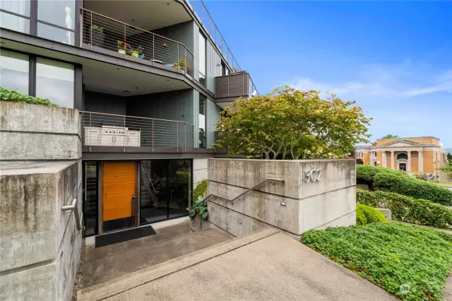 Entrance: The sleek, contemporary exterior of this complex is highlighted by clean lines and modern design elements. The entrance is both grand and inviting, with a stylish blend of concrete and natural landscaping. The address prominently displayed adds a touch of sophistication, welcoming you to this exclusive residence.