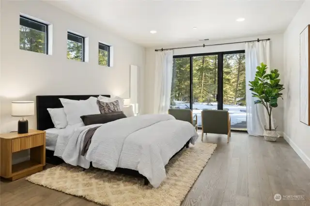 Primary bedroom with private slider leading out to back patio and gas firepit.