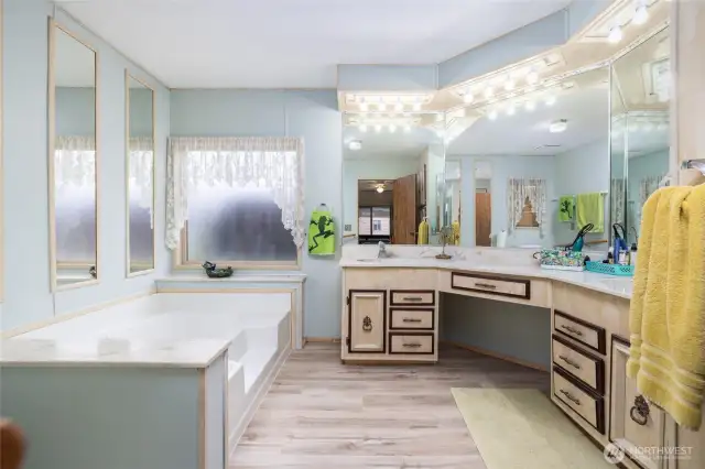 Spacious primary bathroom with dual sinks and a large soaking tub