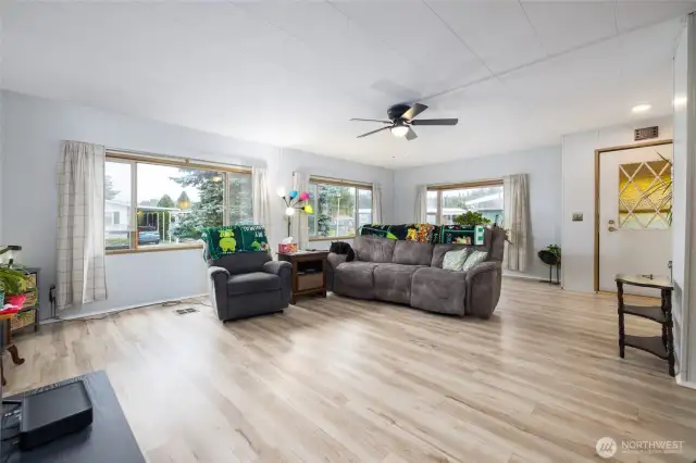 Another view of the living room shows the multiple windows and abundant natural light