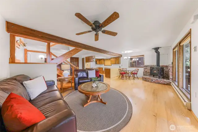 Open flow from the living room to the dining room with a warm gas fireplace.