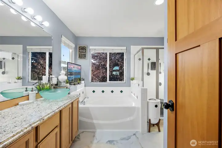 Primary en-suite bathroom with large vanity, soaking tub