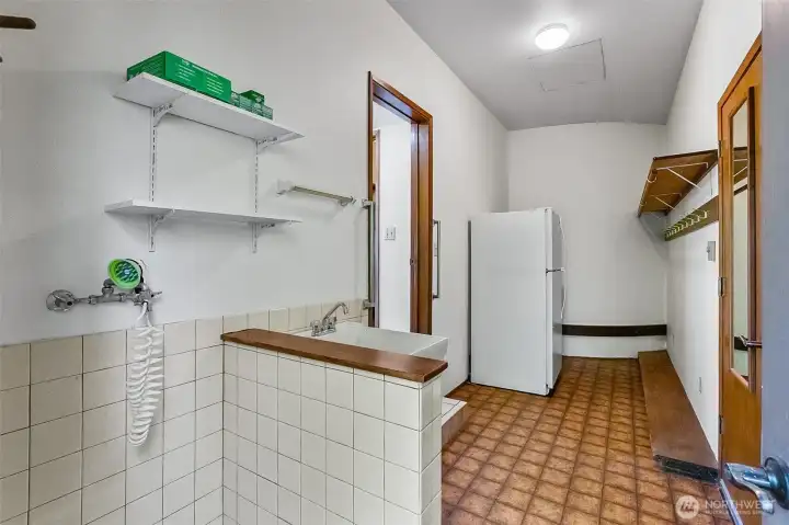Mud room (of kitchen) features a dog washing station and plenty of room for a refrigerator and/or freezer.