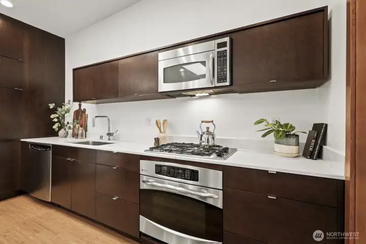 Quartz countertops and stainless steel appliances shine in the fantastic natural light pouring in from above.