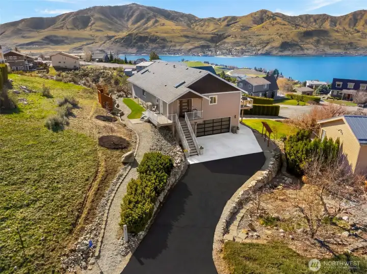 Located next to a community green space in Lake Chelan Hills, this home enjoys  enhanced privacy, extra outdoor space, and a peaceful setting. The level driveway has space for lots of parking in addition to the attached 2 car garage.