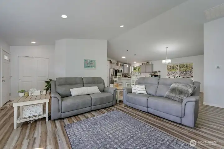 Open concept living with vaulted ceilings and seamless flow into the kitchen and dining areas.