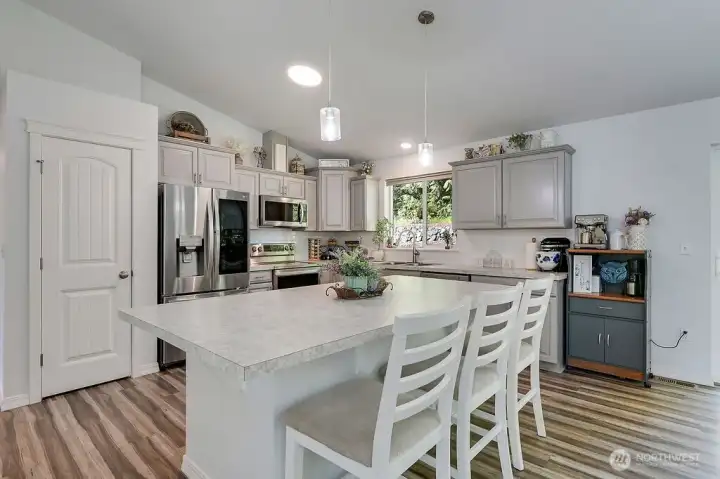 Thoughtfully designed kitchen with ample cabinetry, stainless steel appliances and a central island for casual dining.