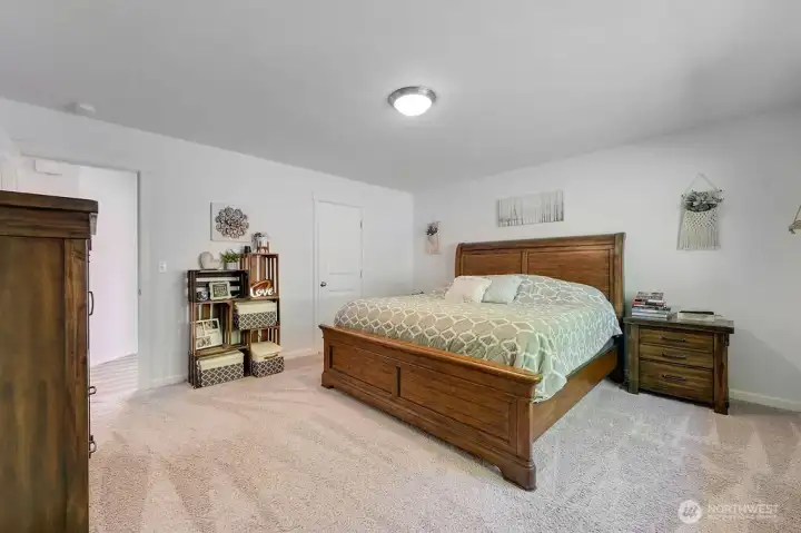 Primary bedroom with easy access to ensuite bath.  Looks out to the very private backyard setting.