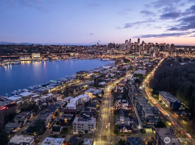 High-altitude twilight: downtown’s skyline shimmers just beyond Lake Union, underscoring your unbeatable commuter location. Photos are of model home 2009B.