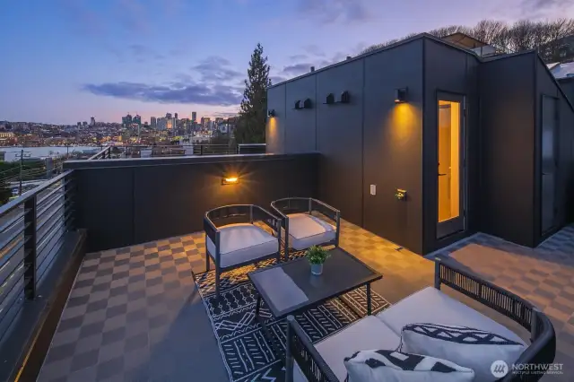 One last twilight glimpse: ambient wall sconces warm the terrace as downtown twinkles beyond—ending the tour exactly where you’ll want to end every day. Photos are of model home 2009B.