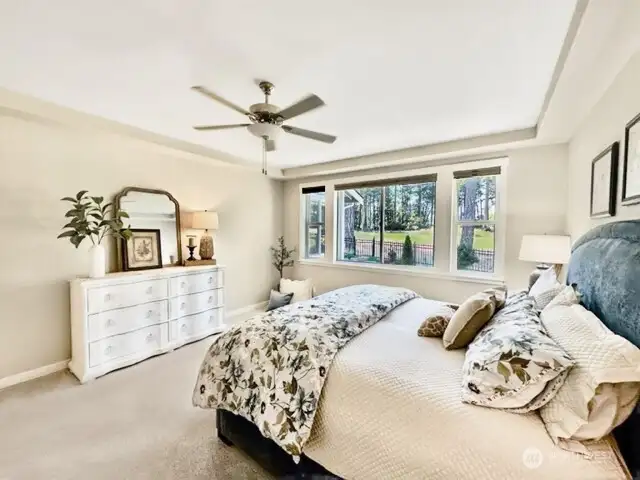 Primary suite offers golf course views, coiffured ceilings and ceiling fan.